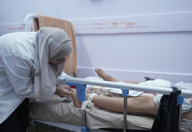 Image of a doctor caring for a patient in an hospital bed.