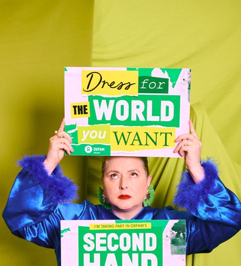 Siobhan McSweeney holding Oxfam's signs "Dress for the world you want" and "Second hand September"