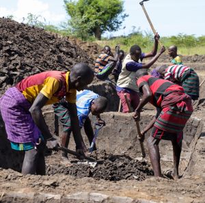 Farmers in Uganda working on a water pond